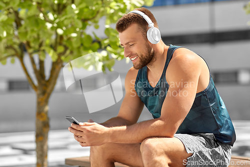 Image of young athlete man with headphones and smartphone