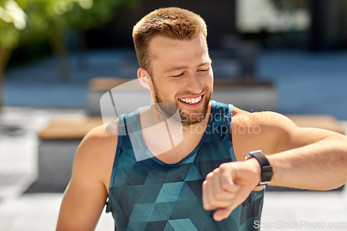 Image of happy man with fitness tracker in city