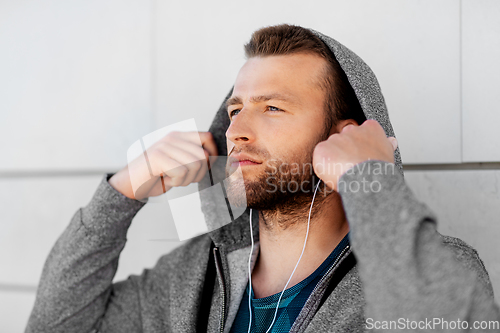 Image of man in earphones listening to music outdoors