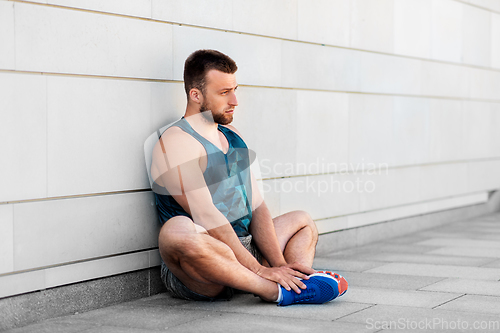 Image of man doing sports and stretching outdoors