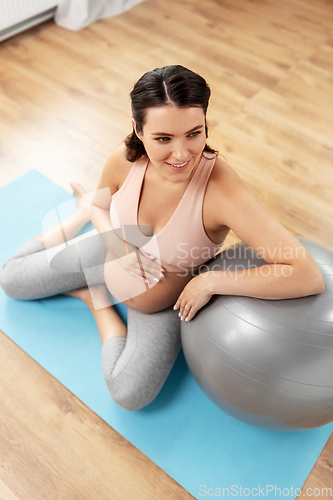 Image of happy pregnant woman with fitball at home