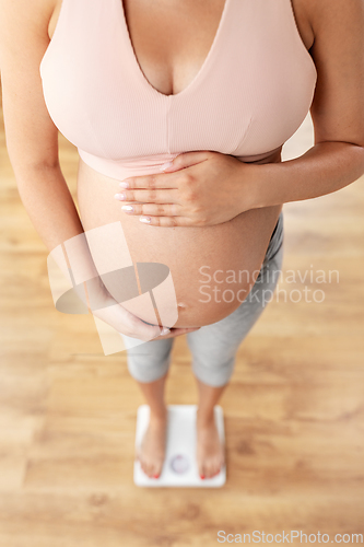 Image of close up of pregnant woman standing on scales