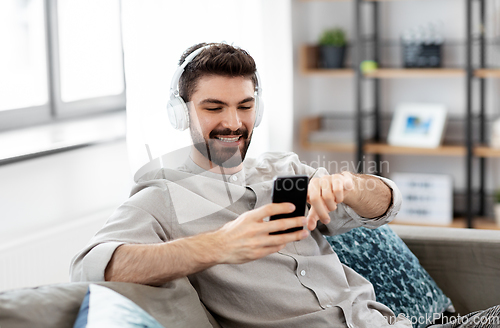 Image of man in headphones listening to music on smartphone