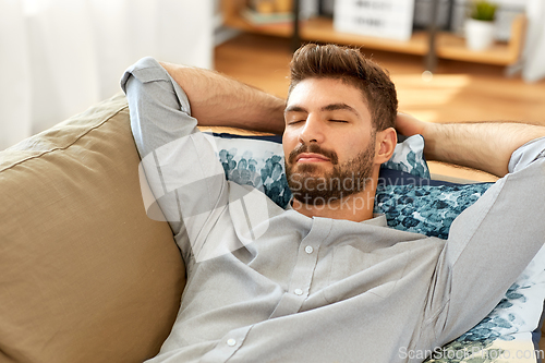 Image of young man sleeping on sofa at home