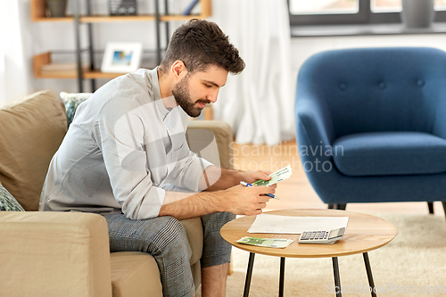 Image of man with money and calculator filling papers