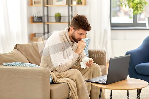 Image of sick man having video call on laptop at home