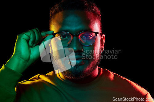 Image of young african american man in glasses over black