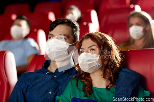 Image of couple in masks watching movie in theater