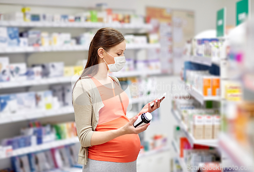 Image of pregnant woman in mask with medicine at pharmacy