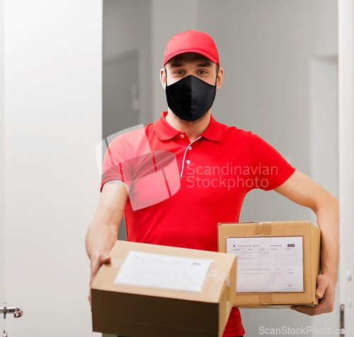 Image of delivery man in mask with parcel boxes