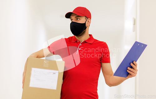 Image of delivery man in mask with box and clipboard