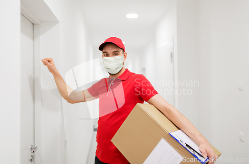 Image of delivery man in mask with parcel knocking on door