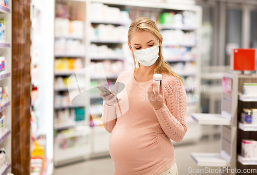 Image of pregnant woman in mask with medicine at pharmacy