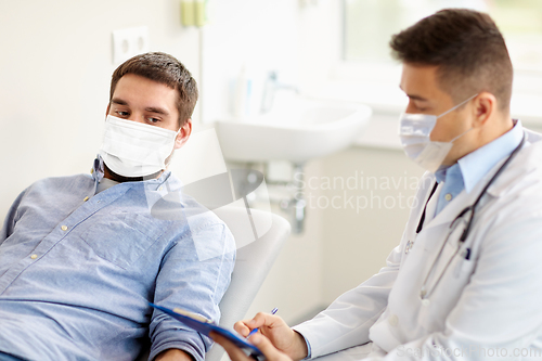 Image of male doctor and patient in masks at hospital