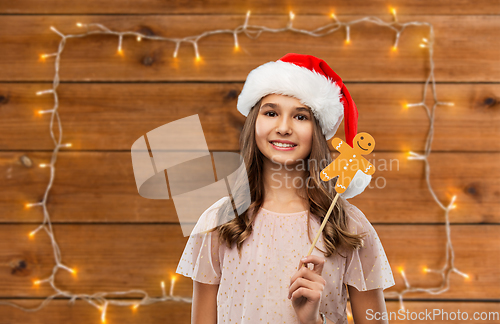 Image of happy teenage girl in santa hat on christmas