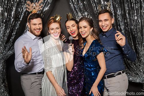 Image of friends with microphone singing at christmas party