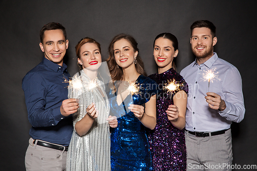 Image of happy friends in party clothes with sparklers