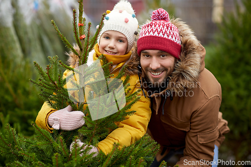 Image of happy family choosing christmas tree at market