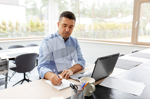 Image of man with laptop working at home office