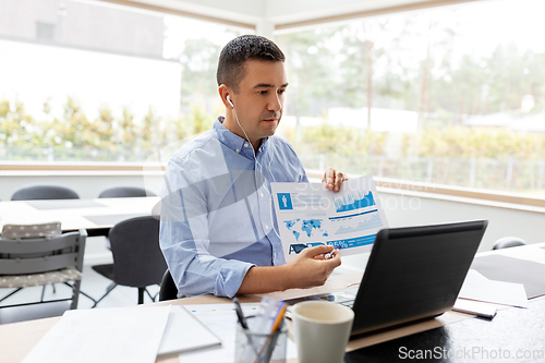 Image of man working and having video call at home