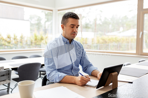 Image of man with tablet computer working at home office