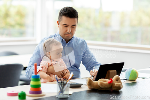 Image of father with baby working at home