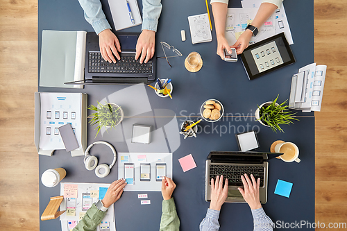 Image of business team with gadgets working at office table