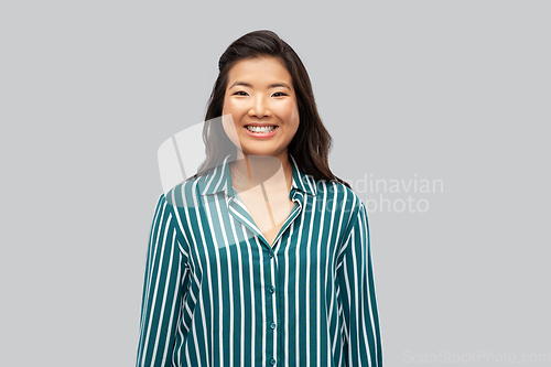 Image of happy asian woman over grey background