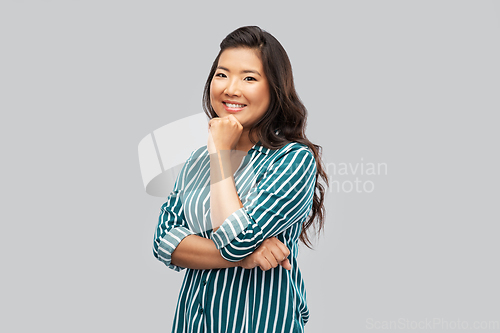 Image of happy asian woman over grey background