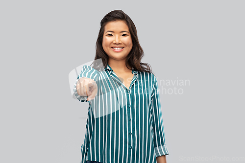 Image of happy asian woman pointing finger to camera