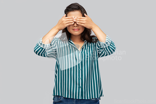 Image of woman with eyes closed by hands