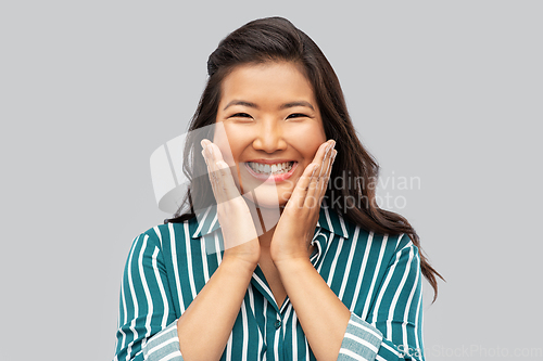Image of happy asian woman over grey background