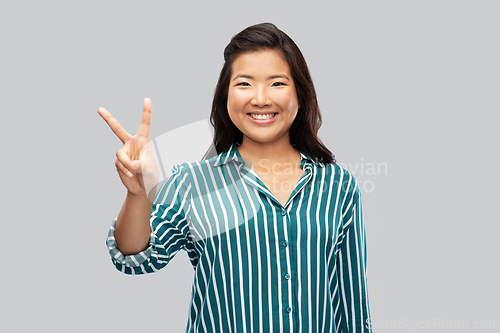 Image of happy asian woman showing peace hand sign