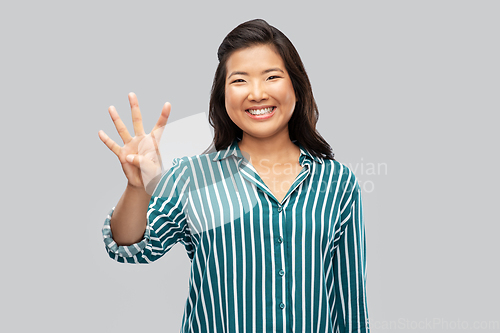 Image of happy asian woman showing four fingers