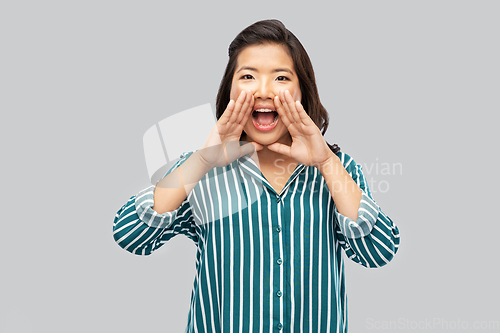 Image of young asian woman calling for someone