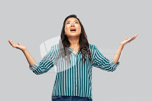 Image of happy asian young woman looking up