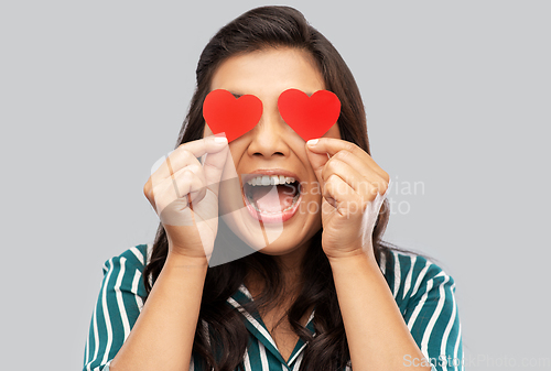 Image of happy asian woman covering her eyes with red heart