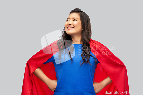 Image of happy asian woman in red superhero cape