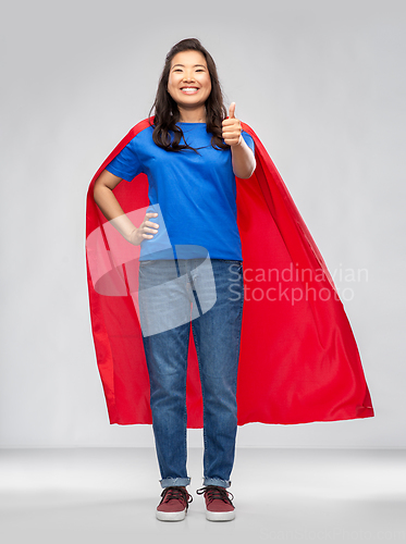 Image of asian woman in superhero cape showing thumbs up