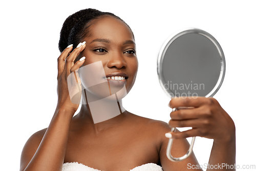 Image of smiling african american woman looking to mirror