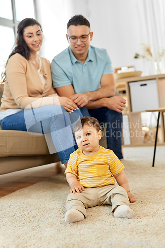 Image of happy family with child sitting on sofa at home