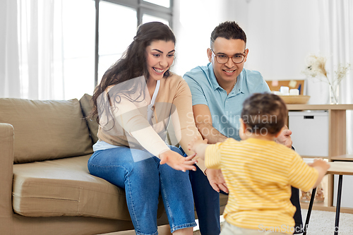 Image of happy family with child sitting on sofa at home