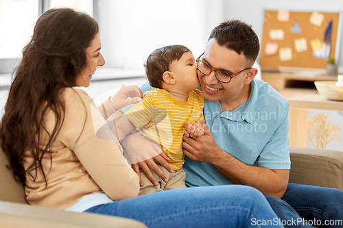 Image of happy family with child sitting on sofa at home