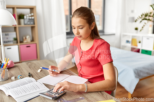 Image of student girl counting on calculator at home