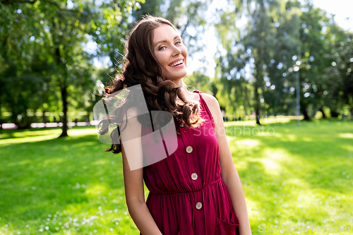 Image of portrait of happy smiling woman at summer park