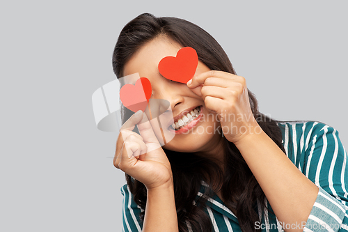 Image of happy asian woman covering her eyes with red heart