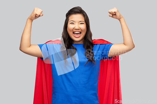 Image of happy asian woman in red superhero cape