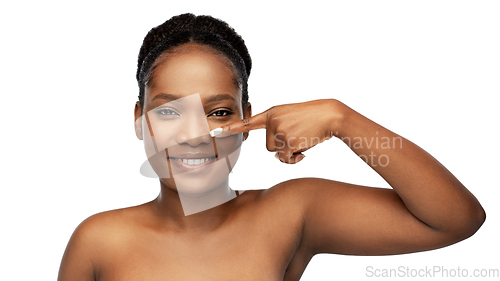 Image of portrait of african woman pointing to her nose