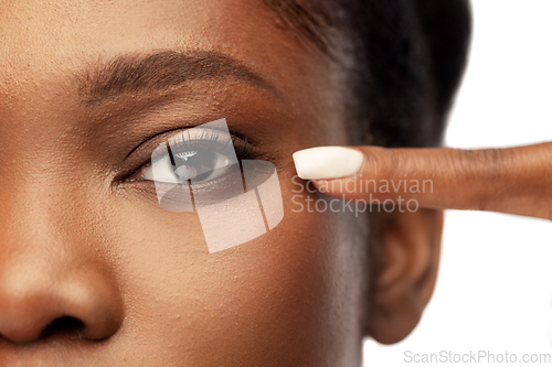 Image of beautiful african woman pointing to her eye