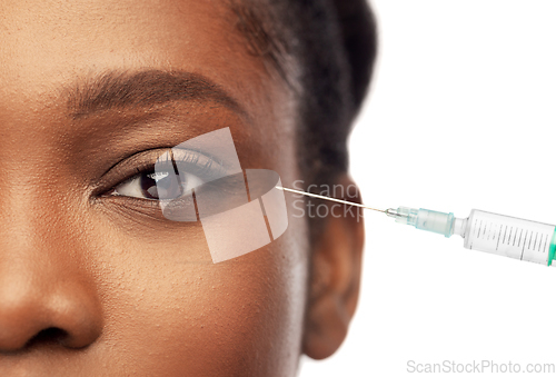 Image of close up of face of african woman and syringe